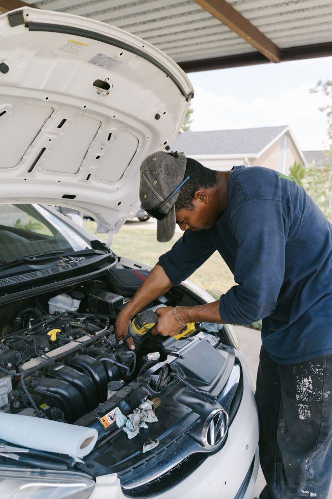 Newport News mobile mechanic working under the hood at a carport